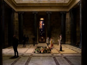Children look up at a Shine Guard in historic uniform in the Sanctuary, Shrine of Remembrance