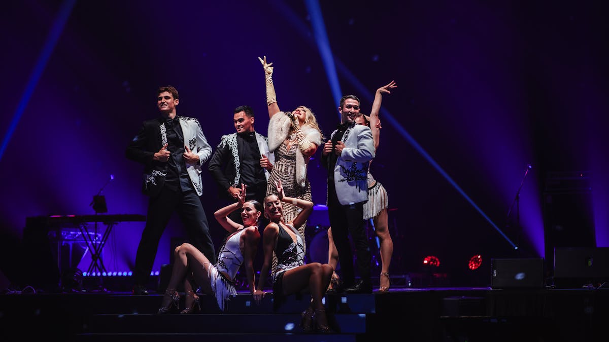 Dancers and a singer in Gatsby costumes pose