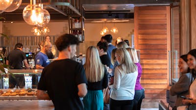 lINE OF PEOPLE WAITING TO COLLECT AND ORDER COFFEE