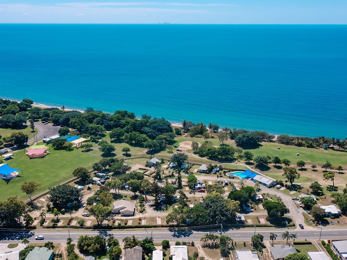 Aerial view of the coastal town of Bowen featuring a beach in the foreground.