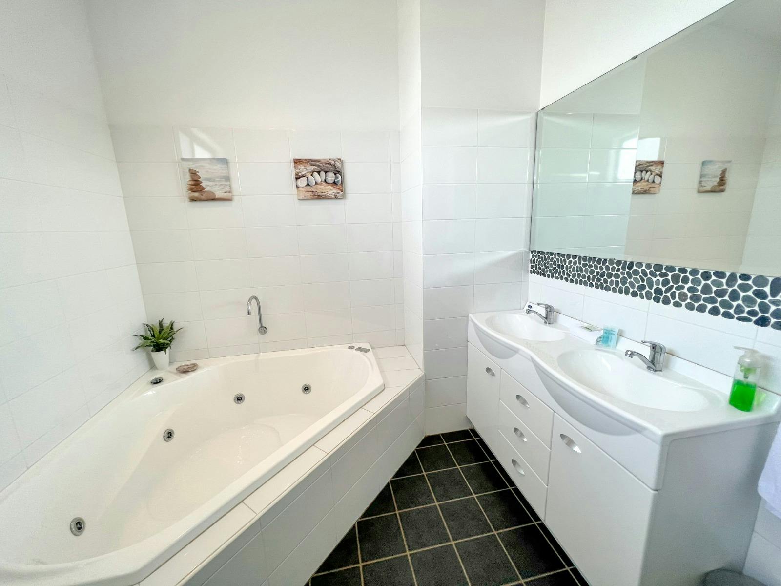 The bathroom features a corner spa bath, the perfect place to unwind at night