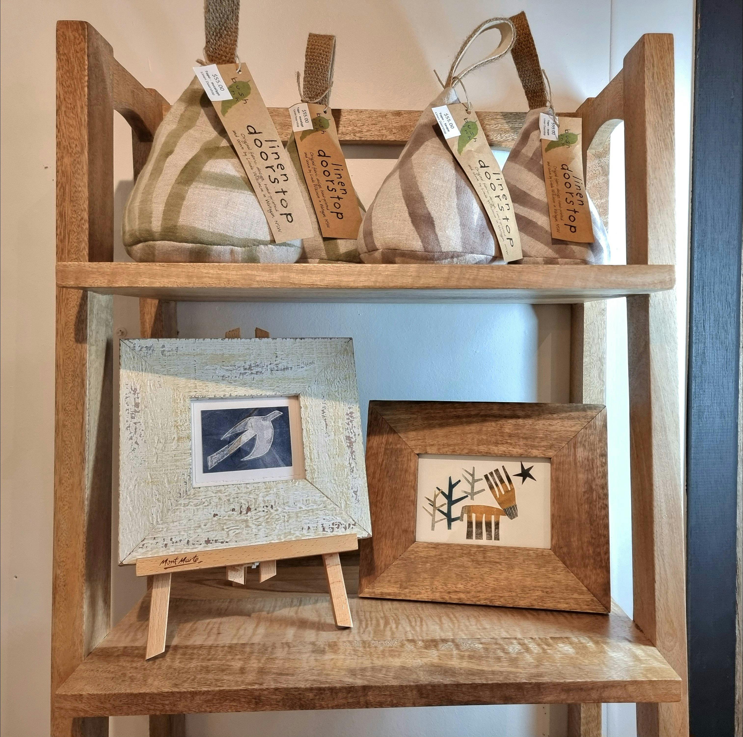 A monoprint of a flying bird, and a collage of a stage in the forest. Both prints are framed.