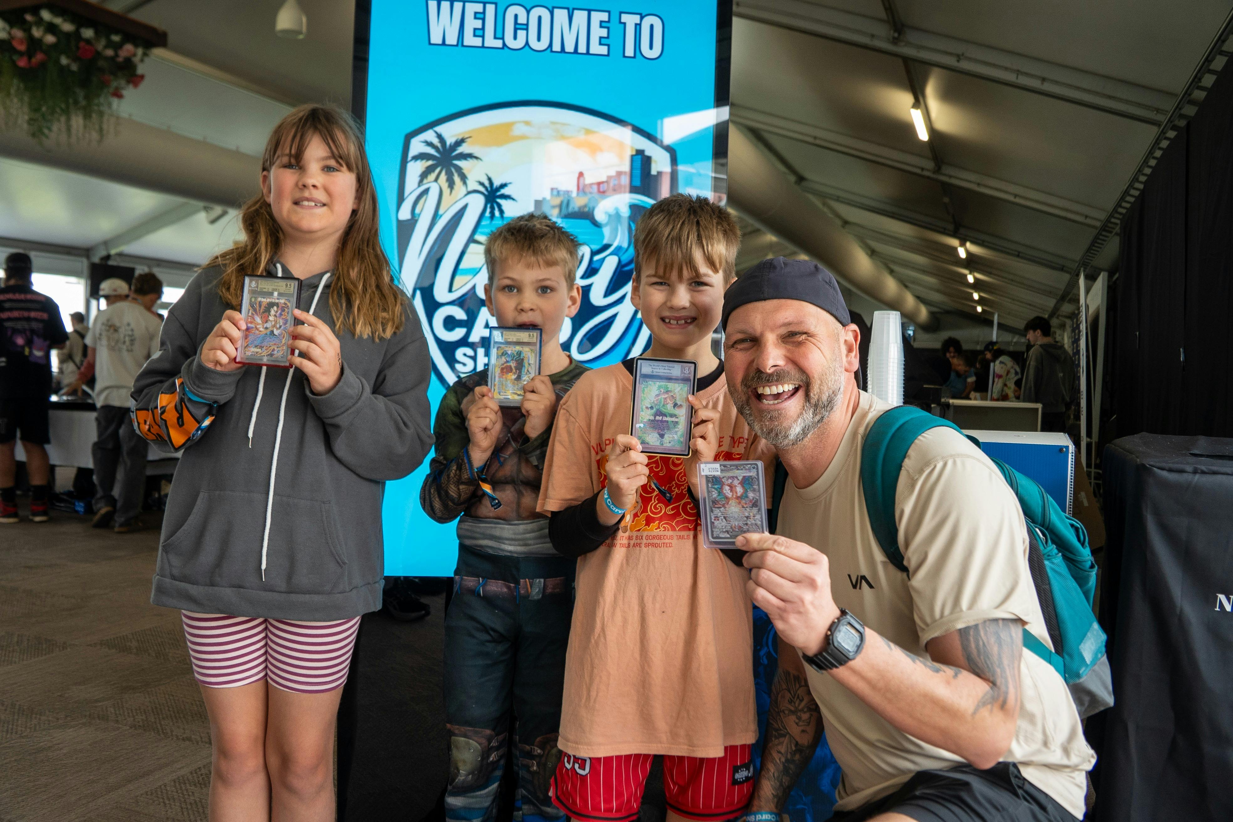 A father and three children show off their trading cards.