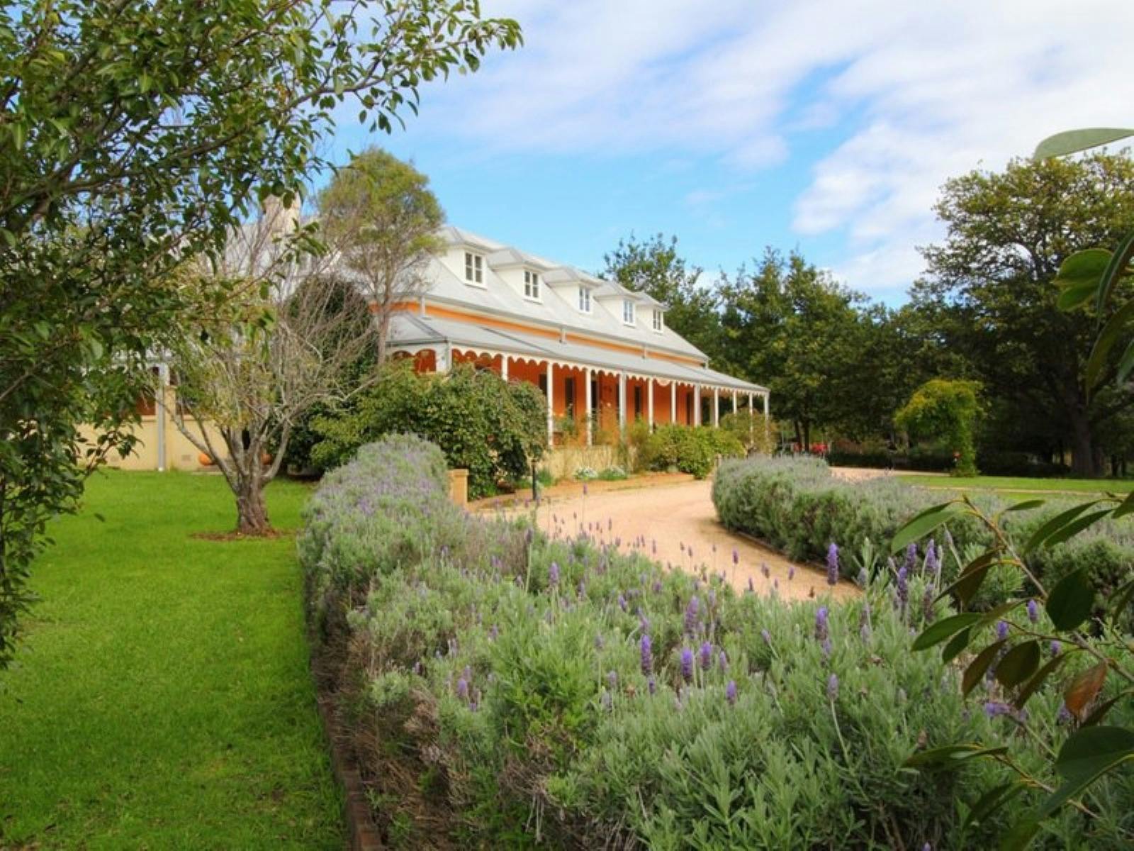 Front view of Fitzroy Inn with the building and heather lined driveway