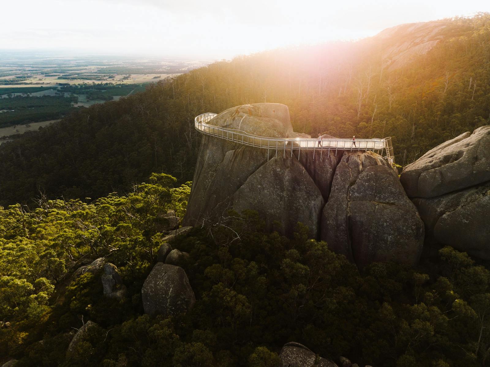 aerial view over steel catwalk attahced to granite hill in bushland