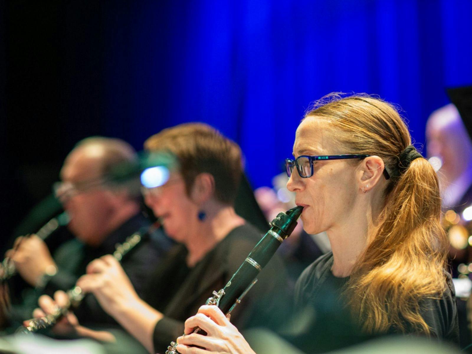 3 people 1 male and 2 female playing wind instruments 3 people 1 male and 2 female playing wind instruments