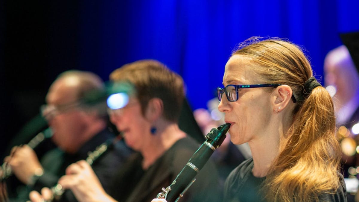 3 people 1 male and 2 female playing wind instruments