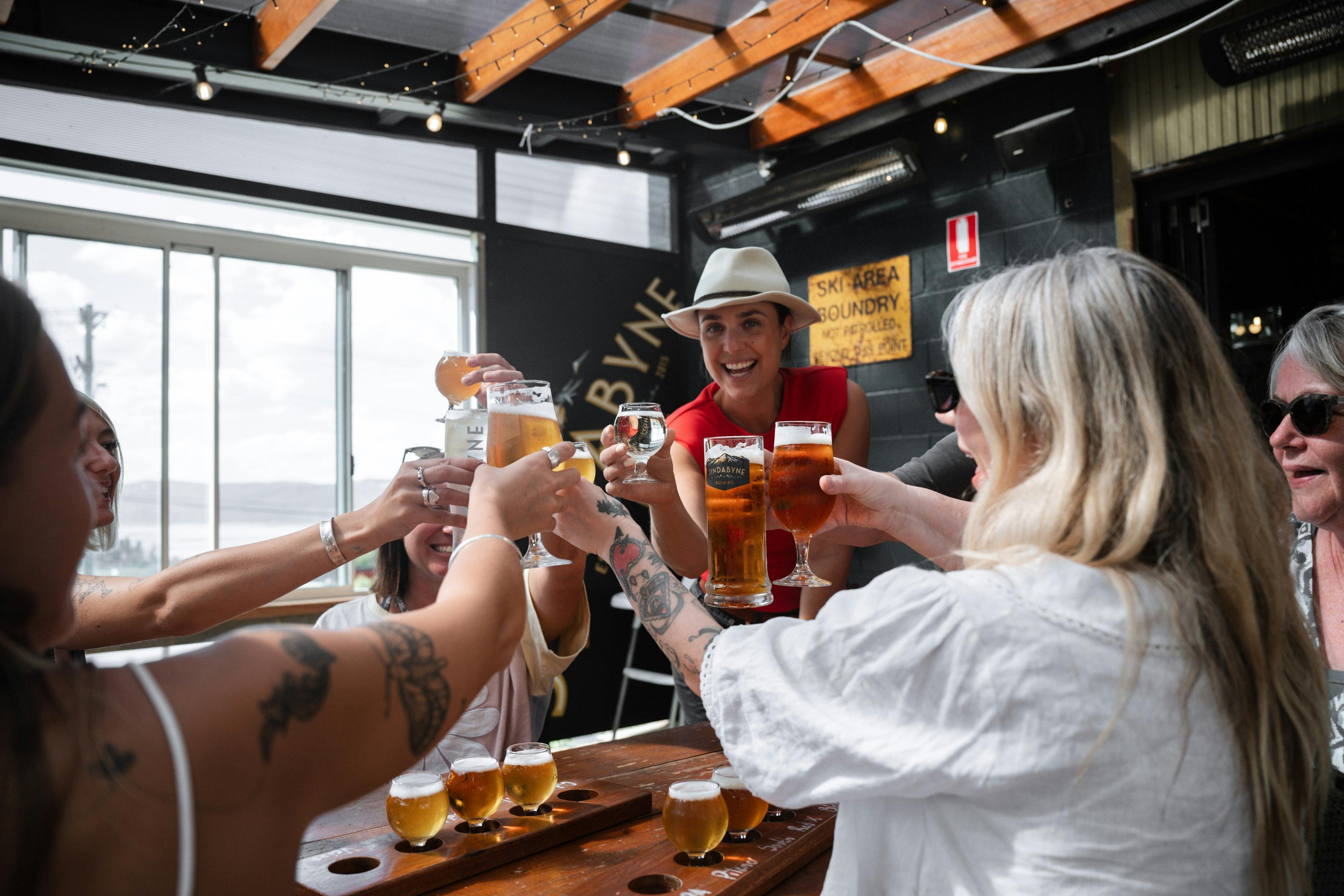 A group of tour guests cheersing their glasses at a brewery