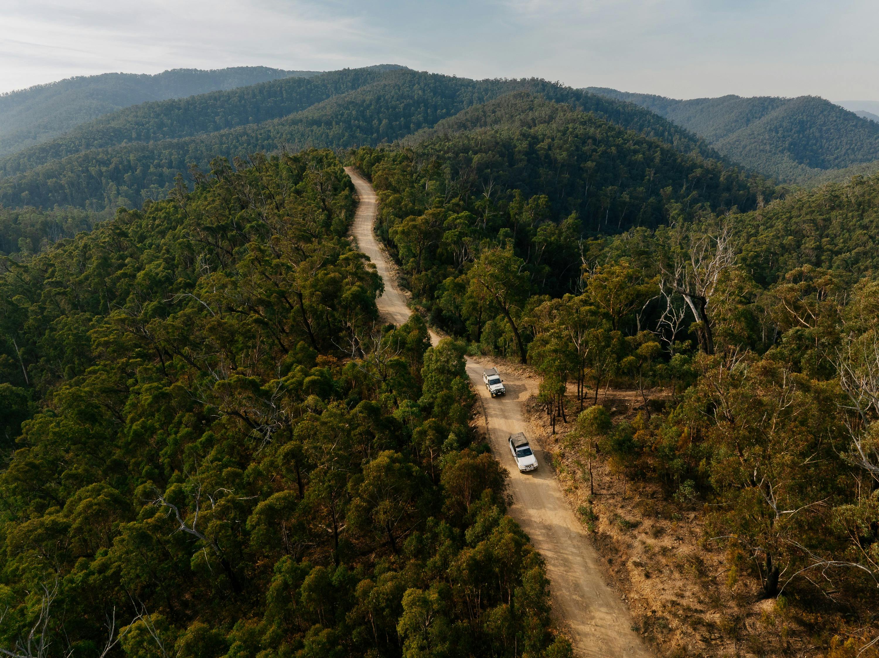 Aerial view of 2 4WD vehicles driving along a mountain road