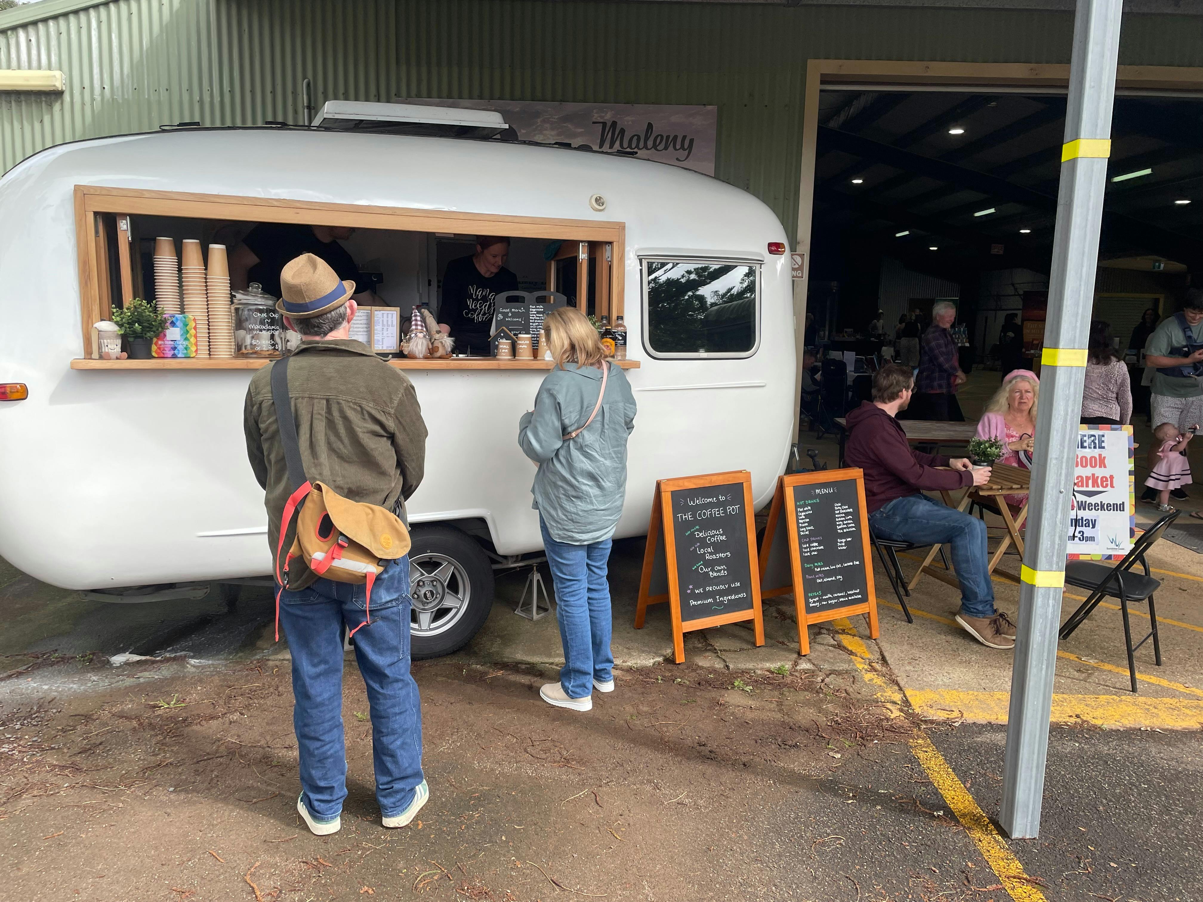 People ordering coffee from a small white van