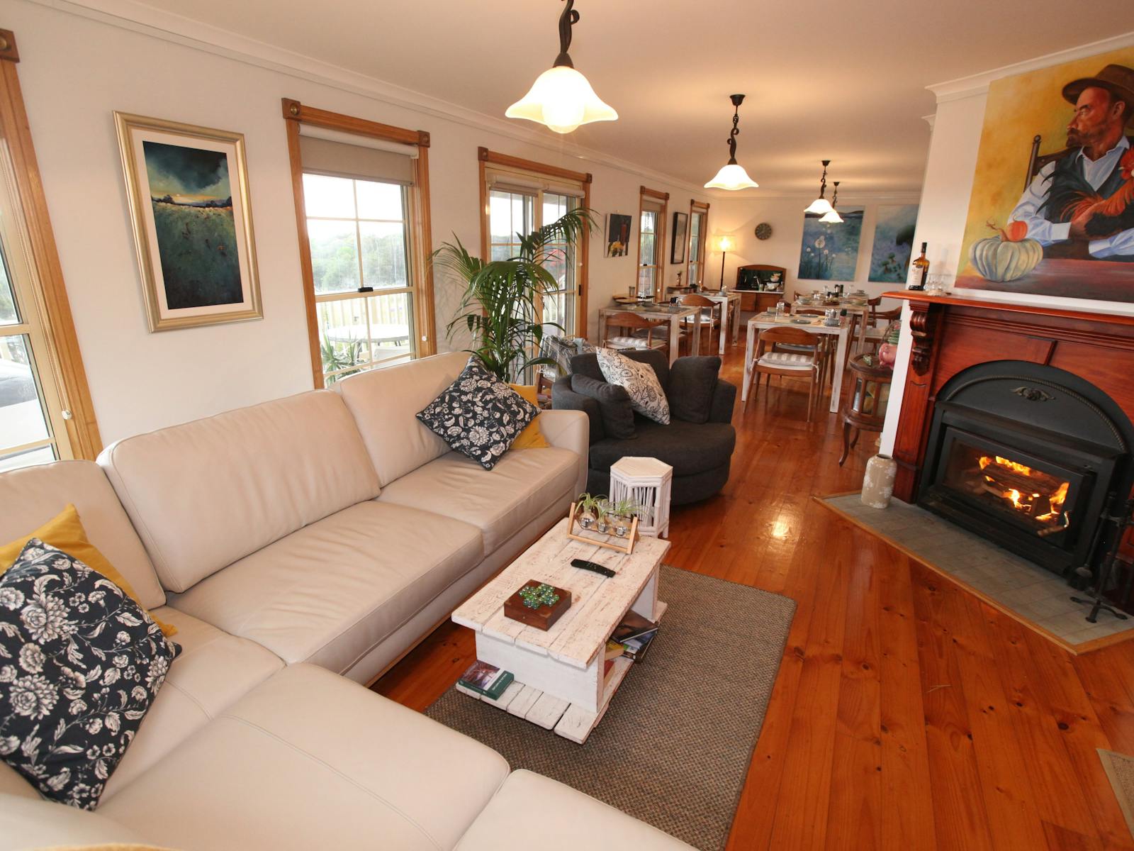 Cream leather lounges, wood fireplace, beach distressed square dining tables with  timber chairs,