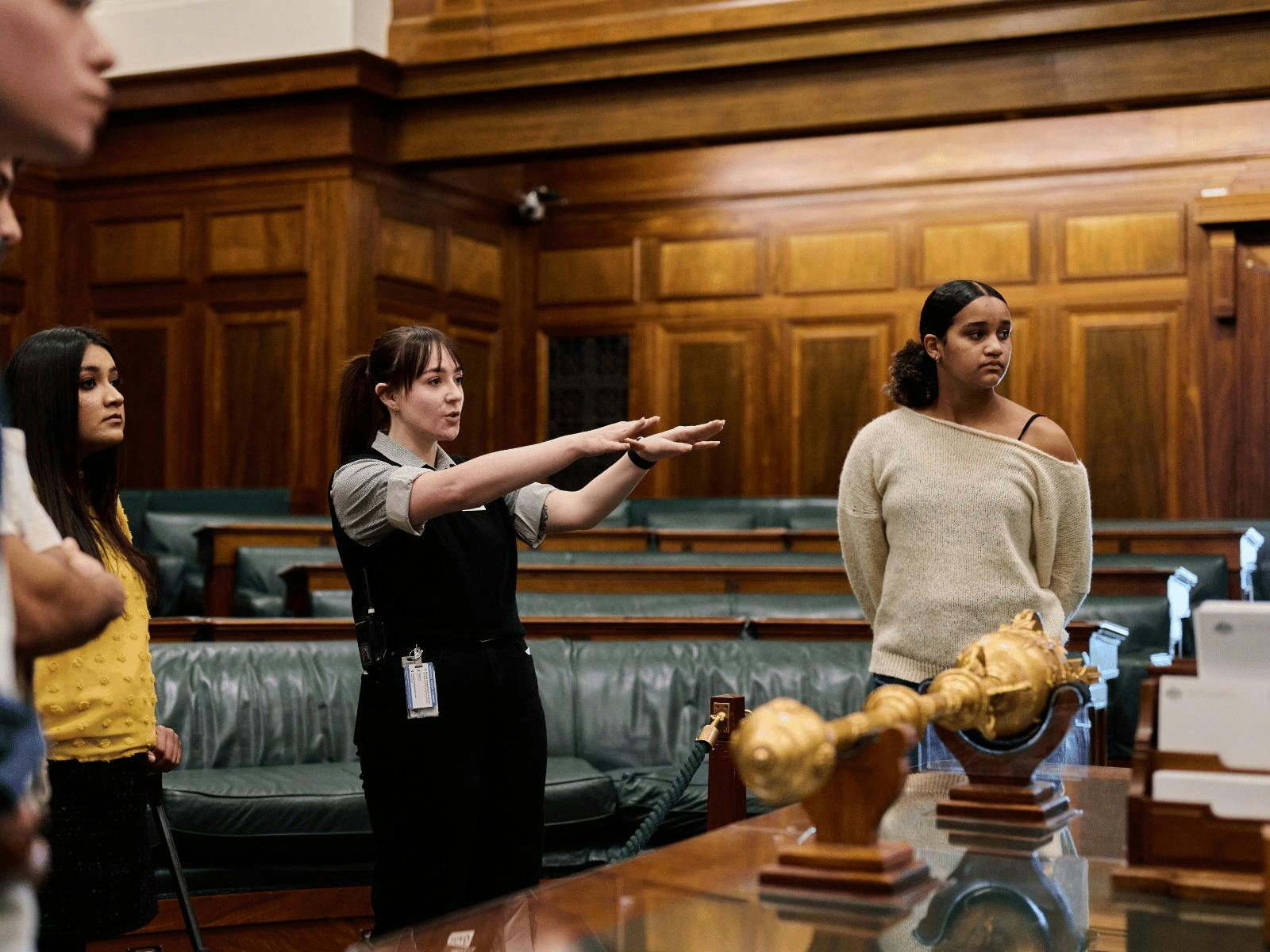 MoAD Experience Officer shows the tour group the House of Representatives chambers