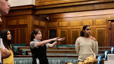 MoAD Experience Officer shows the tour group the House of Representatives chambers
