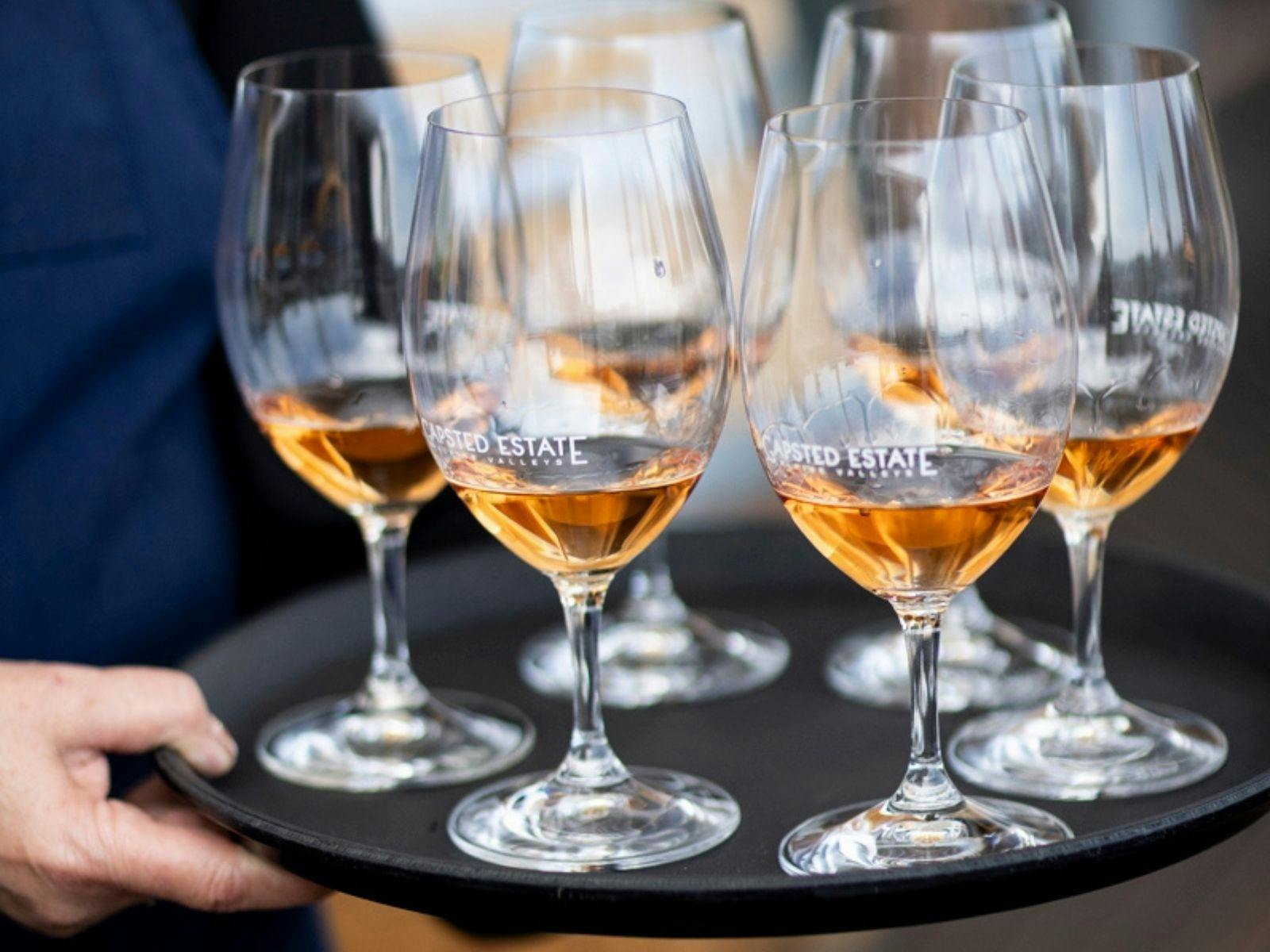 Waitress holding a try with Gapsted Estate wine glasses