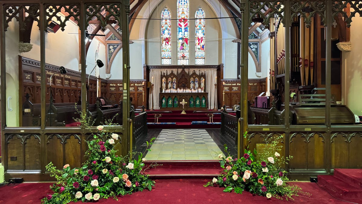 The interior of the church showing the chancel and altar along with stained-glass windows.
