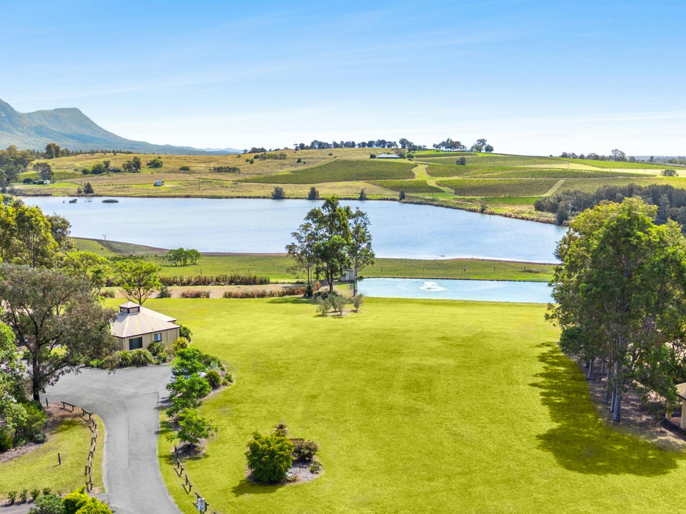 Scenic vineyard landscape with lake and rolling hills in Pokolbin