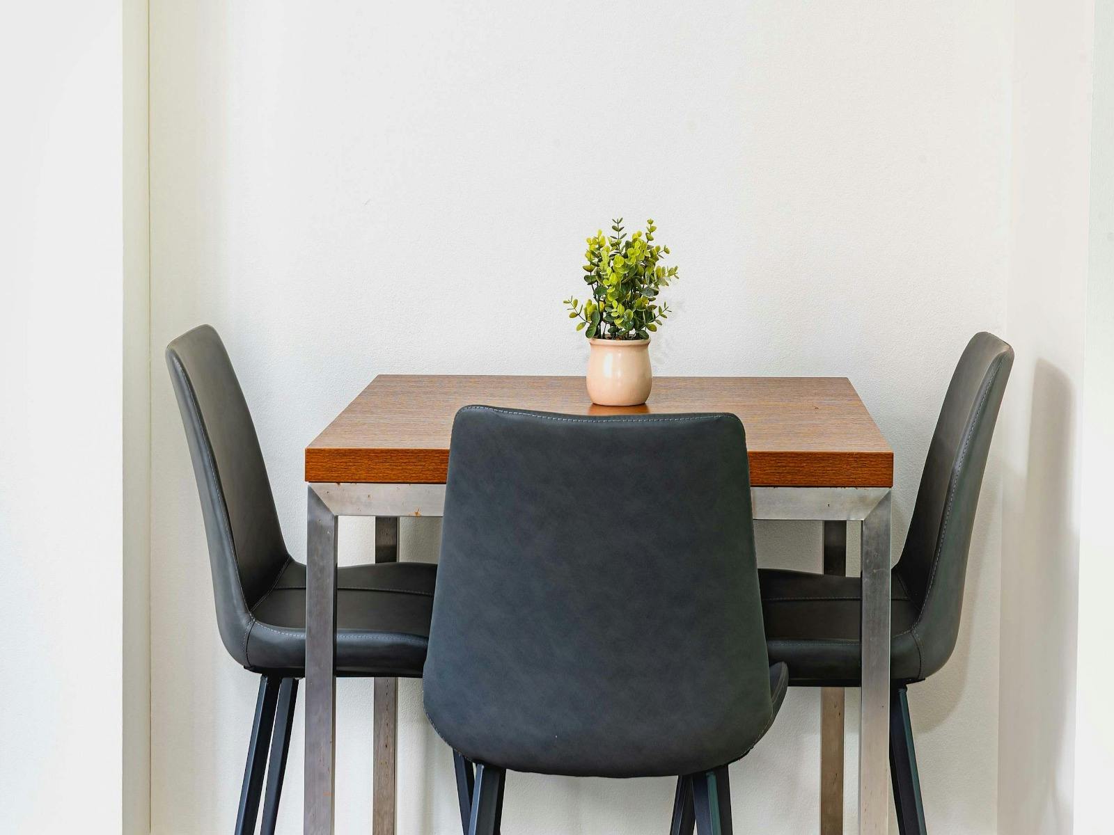 Small dining setting with table and chairs, styled with simple décor.