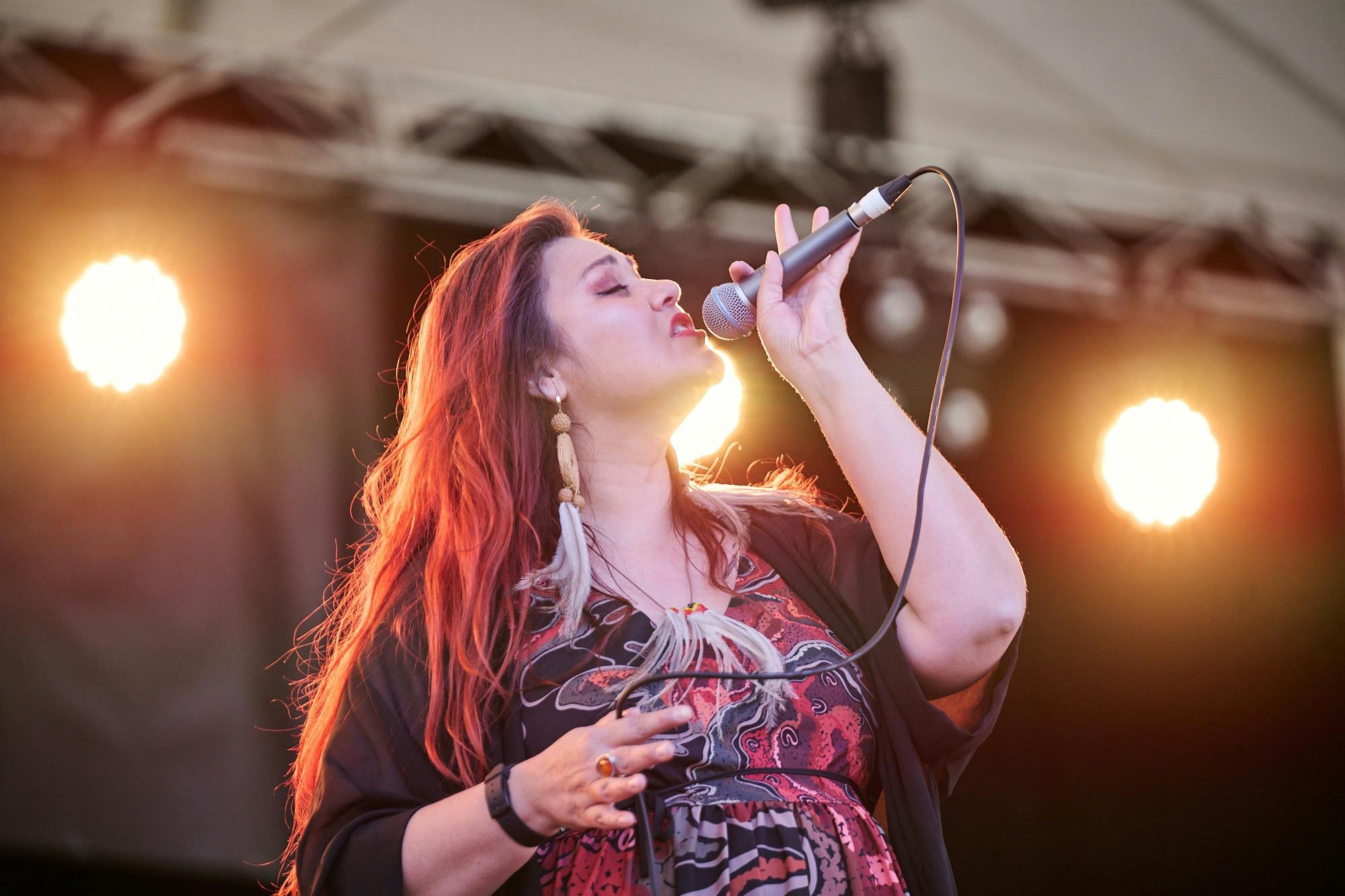 Person singing on stage with a microphone