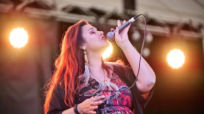 Person singing on stage with a microphone