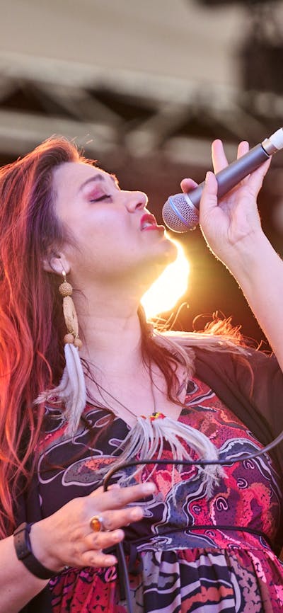 Person singing on stage with a microphone