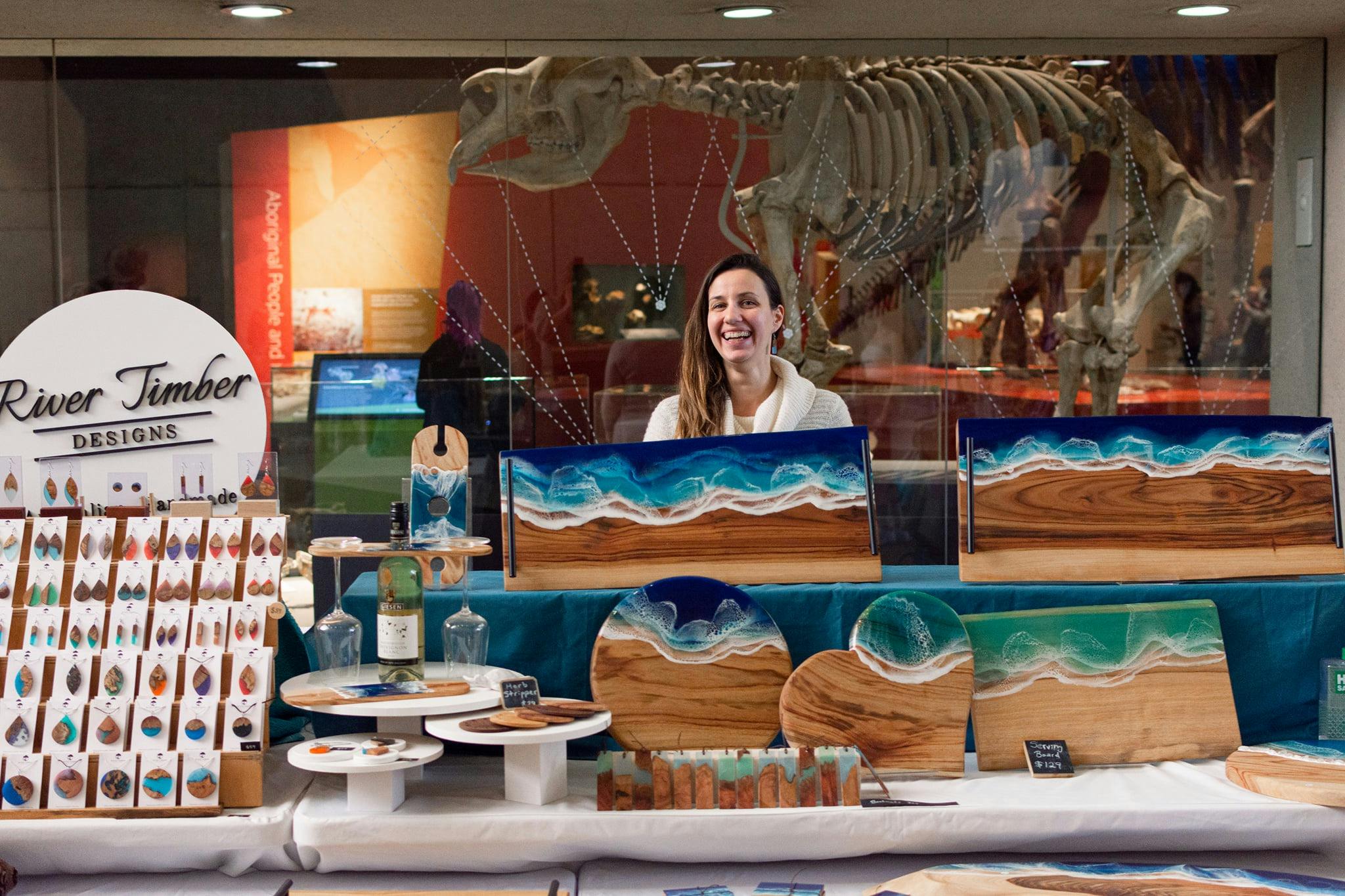 A stall holder set up in front of the museum window with fossils behind them