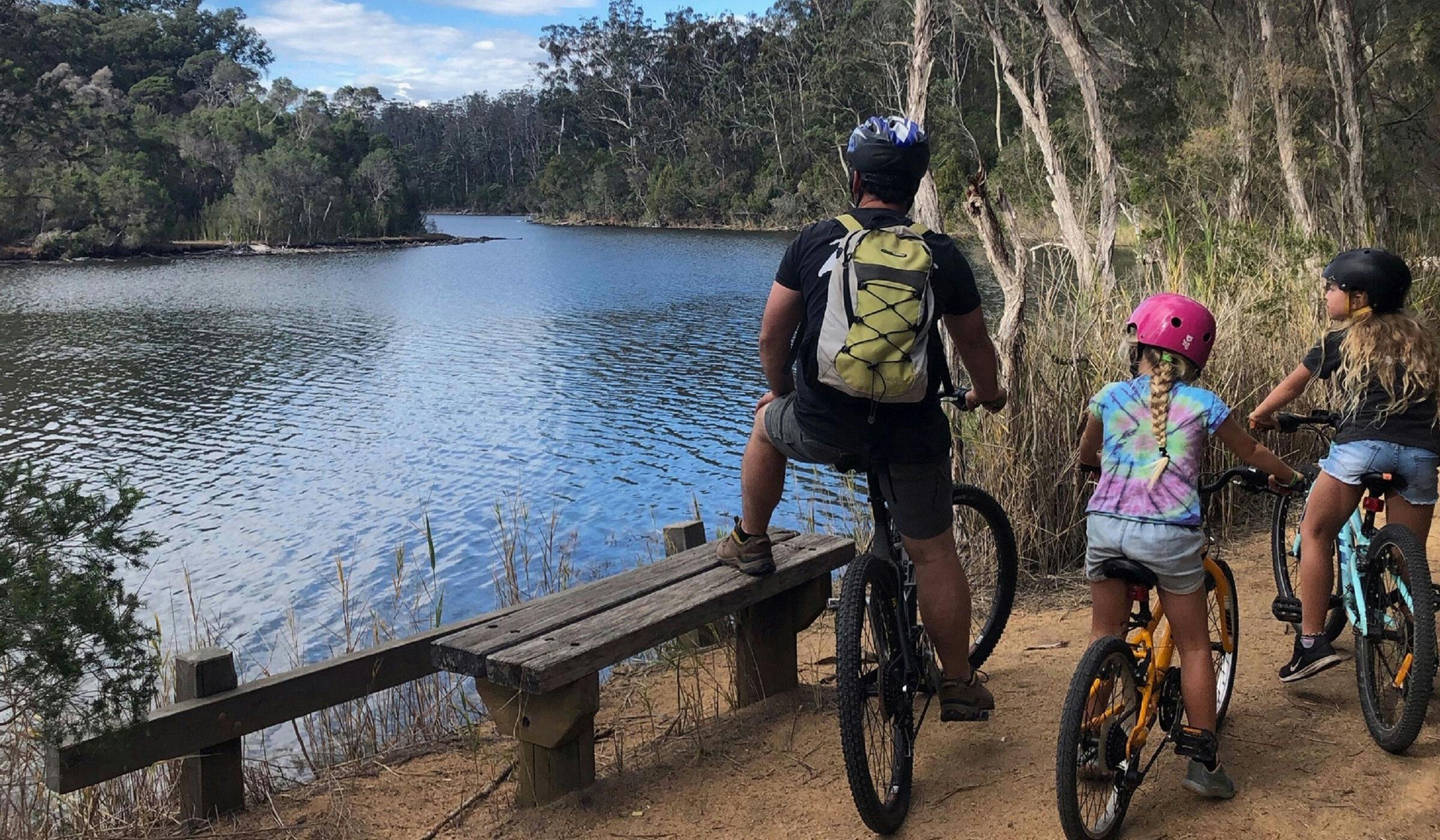 A family on bikes at a lake in Nowa Nowa