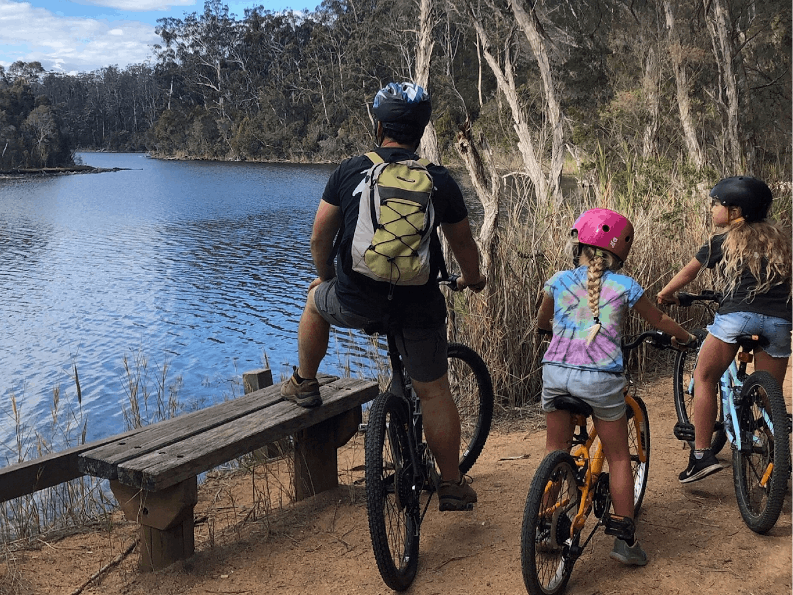 A family on bikes at a lake in Nowa Nowa