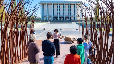 Tour guide Sita with tour group out the front of the National Library of Australia