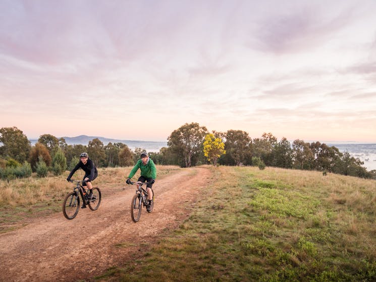 Two cyclists riding along a gravel pathway at the top of Pomingalrana Reserve