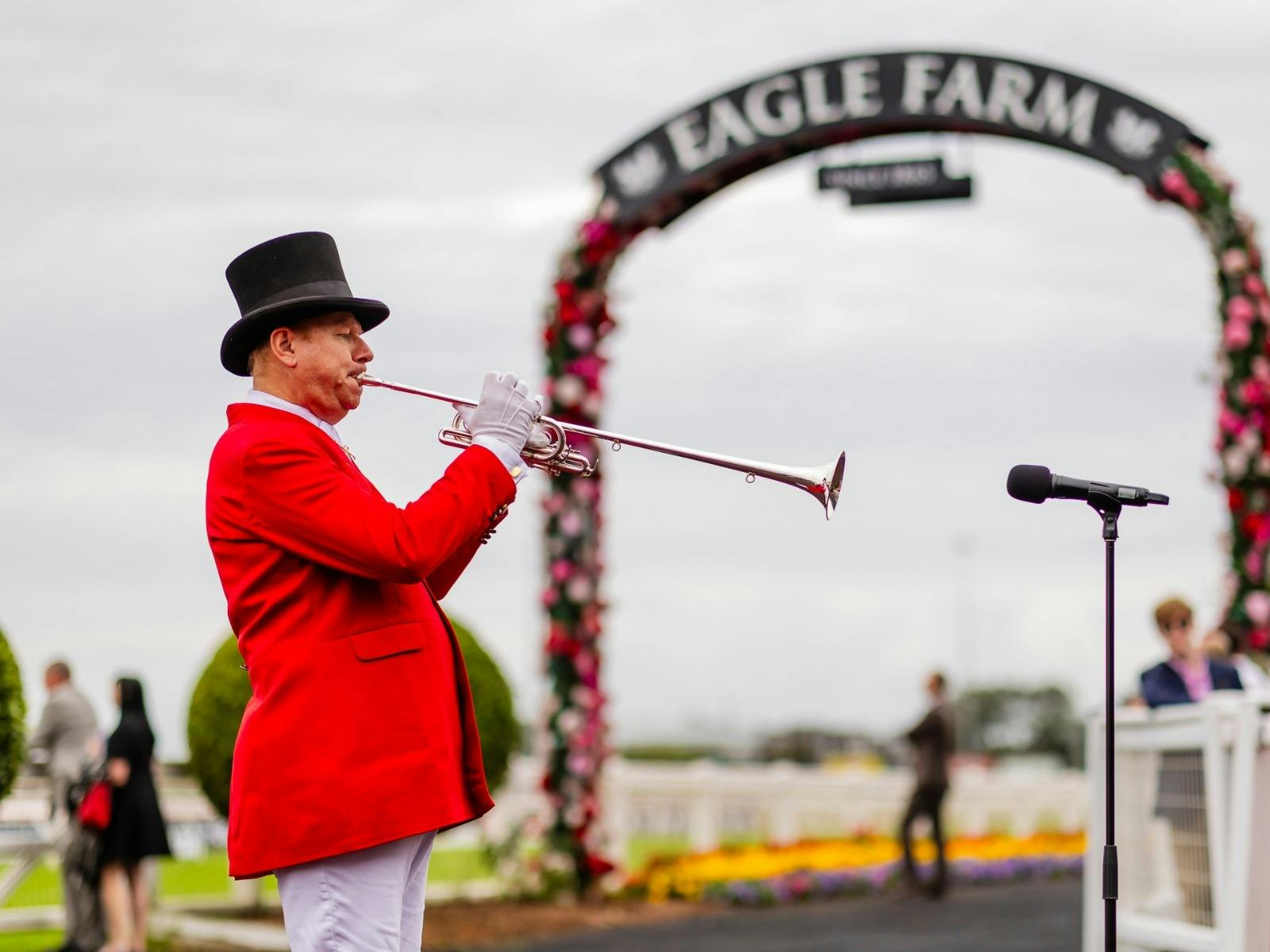 A bugler calls racegoers to the track.