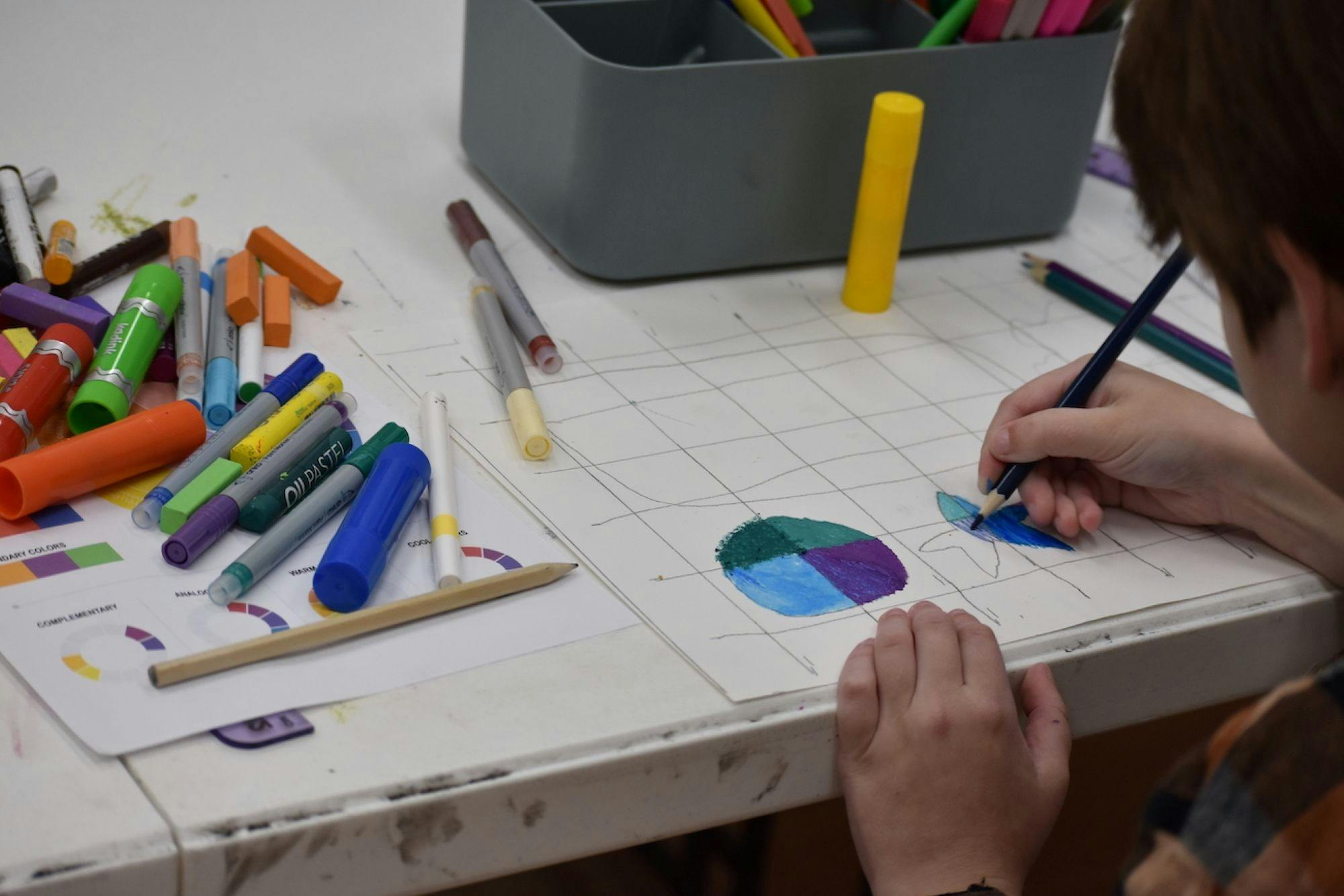 Teenage boy drawing and colouring patterns and shapes