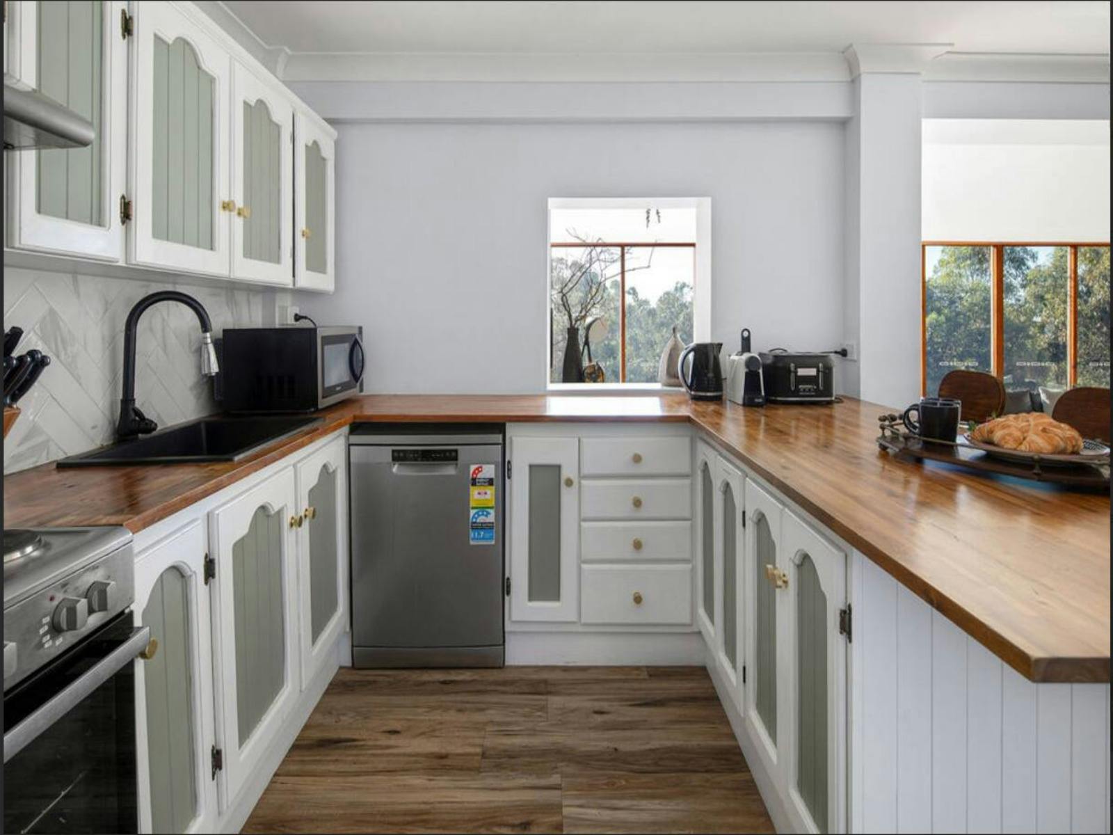 주변 풍경이 보이는 밝고 통풍이 잘 되는 주방에는 나무 조리대가 있습니다.