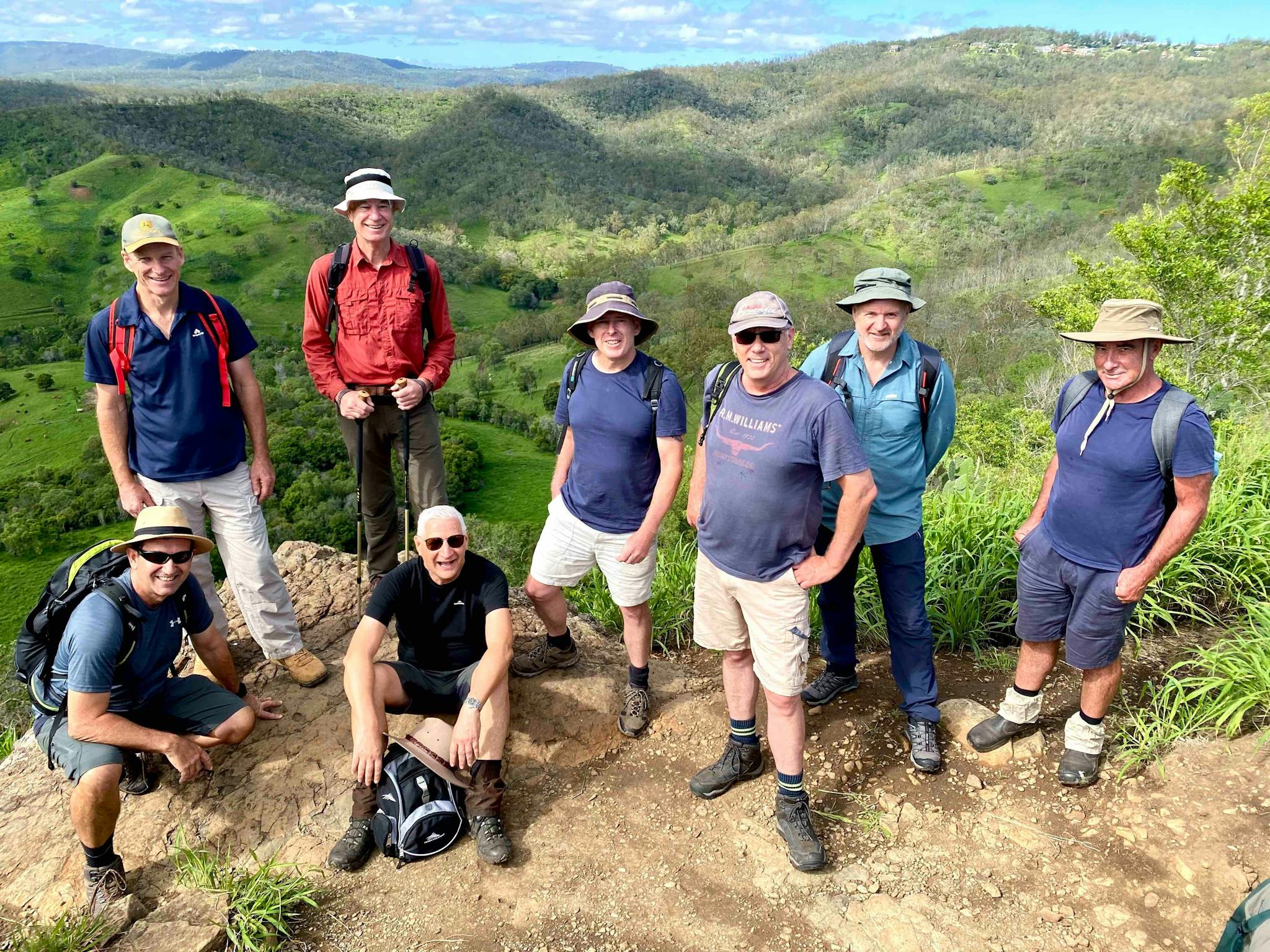 8 men posing for a photo while on a day hike