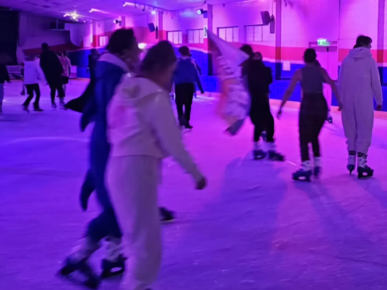 Ice Skaters in a purple lit rink