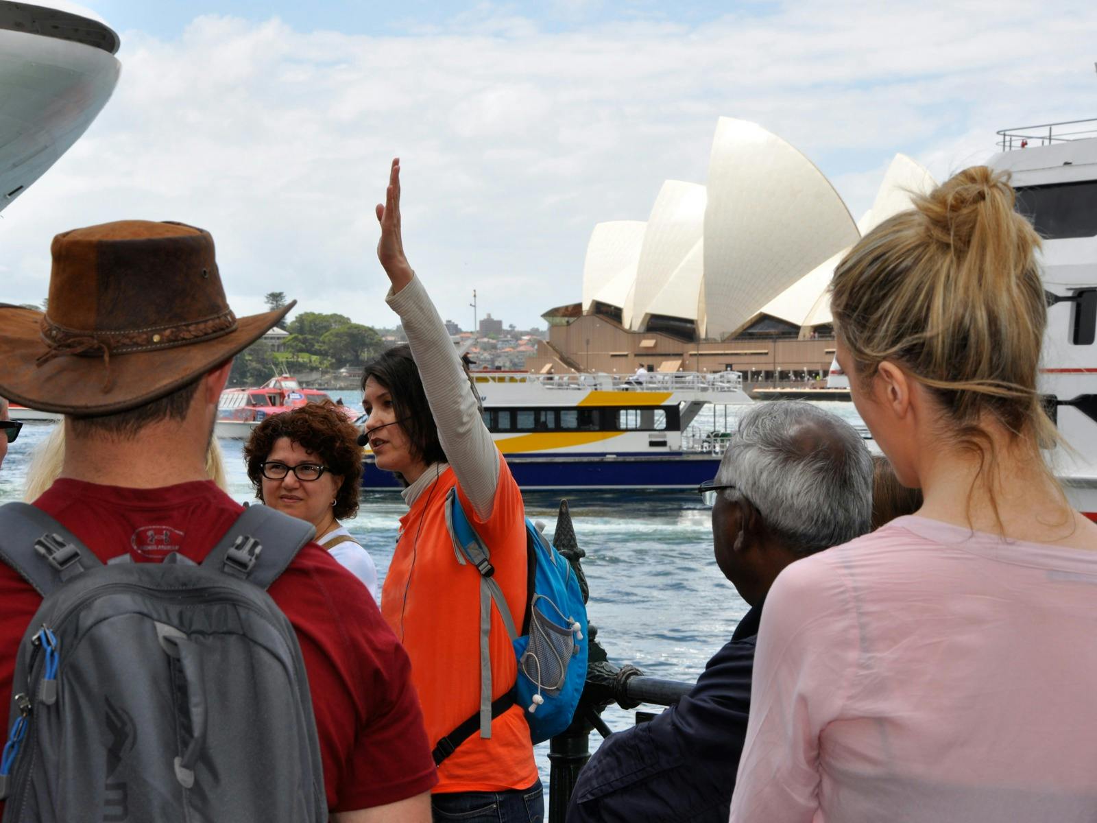 A tour guide with a group of people at Circular Quay. The Sydney Opera House on the background.