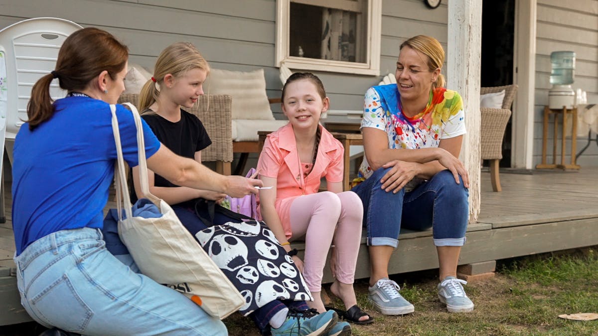 Families and children chat together on a veranda during a Storyfest workshop.