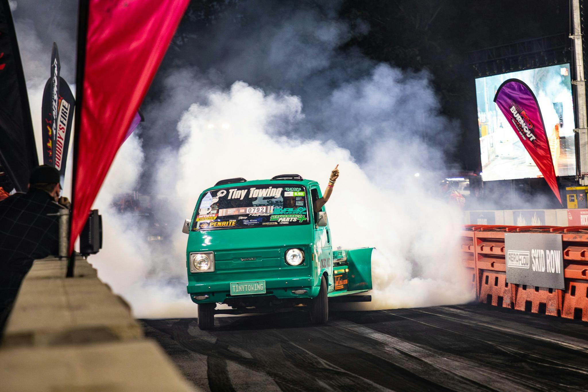 Vehicle performing a burnout on a track with tyre smoke at Rockynats.