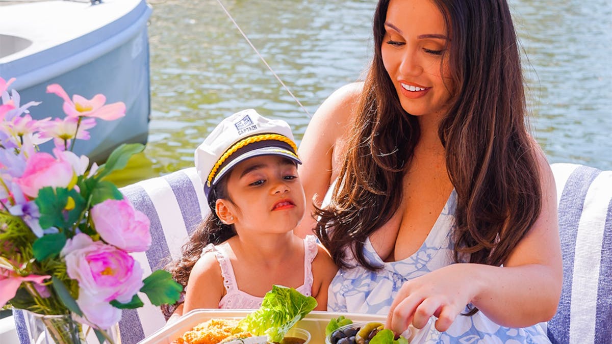 Mother and child enjoying food and drinks aboard a GoBoat picnic boat at Isle of Capri.