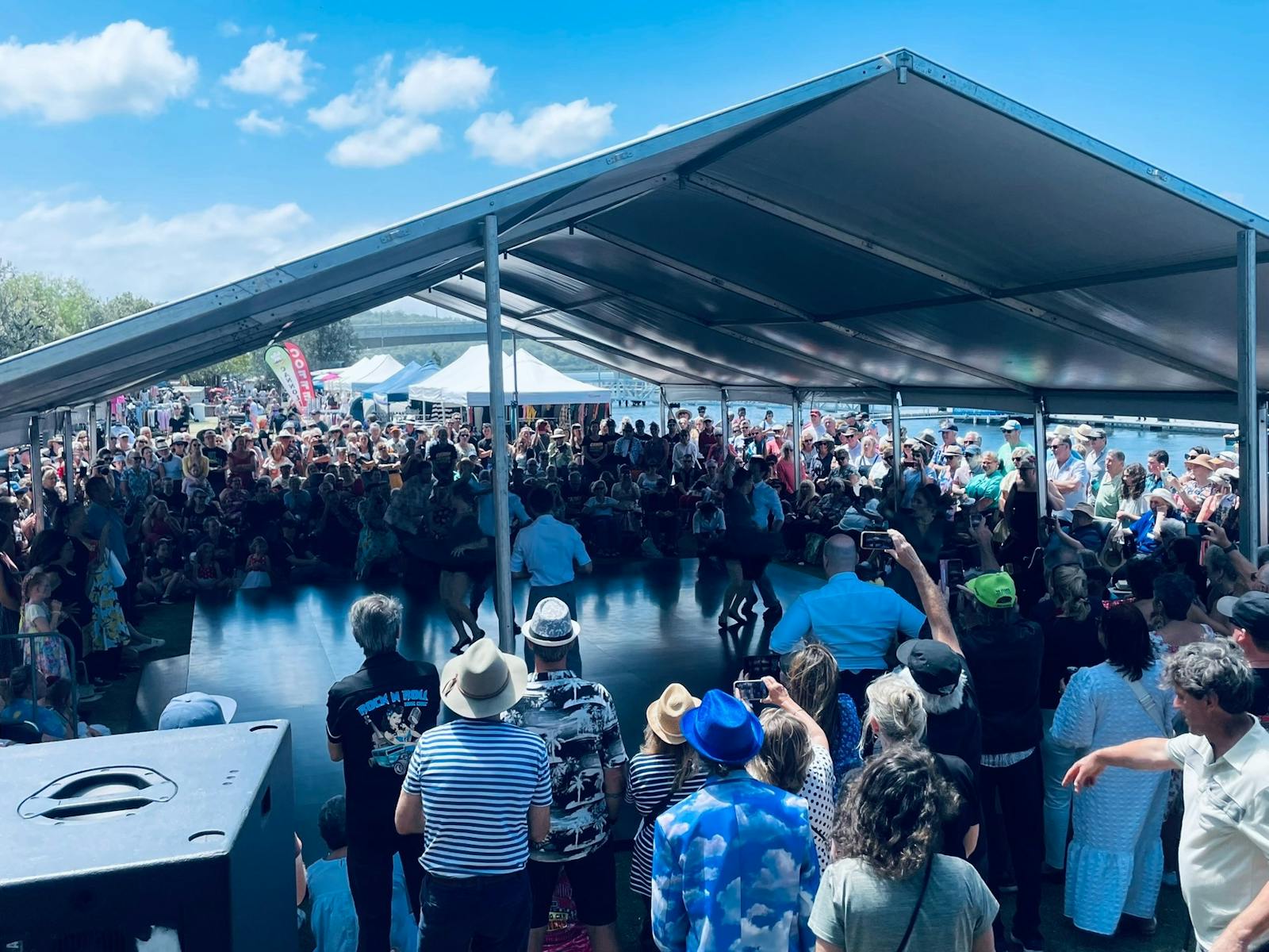 Crowd gather around the large outdoor dancefloor to watch the dancers