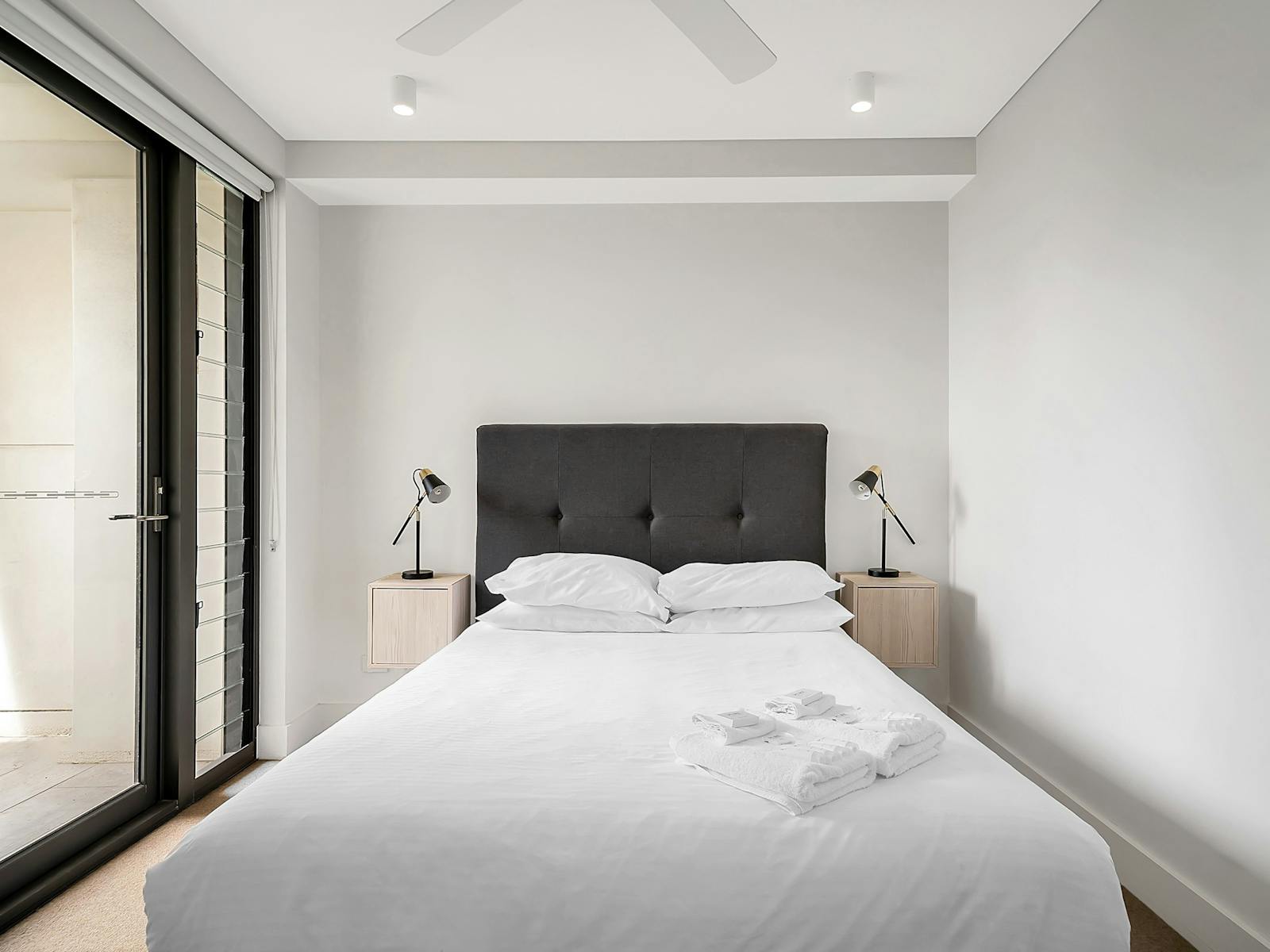 Cozy bedroom with light-filled windows and a stylish modern design.