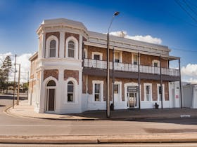 Front view of the Pastoral Hotel Motelu2019s heritage-style main building with intricate ironwork detail