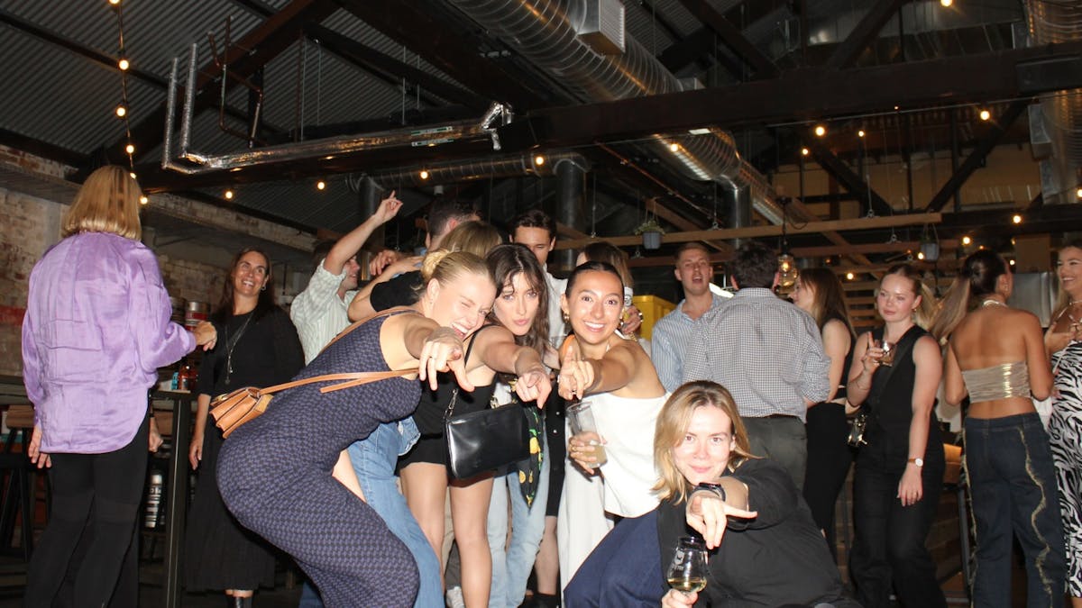 Groupd of young women posing for the camera near the bar