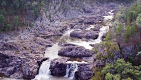 River and small falls in rocky ravine.