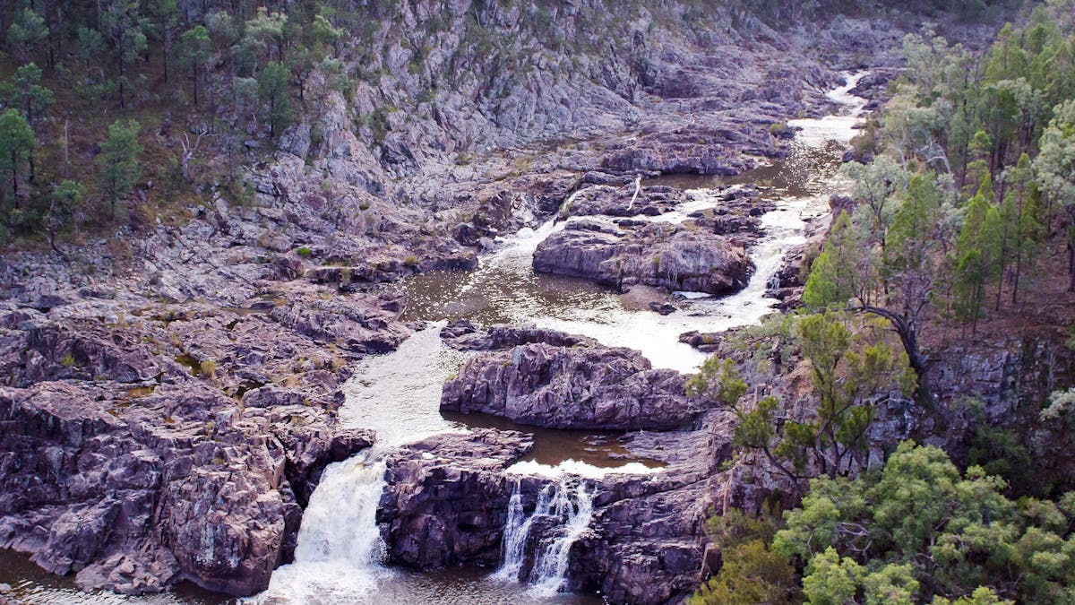 River and small falls in rocky ravine.