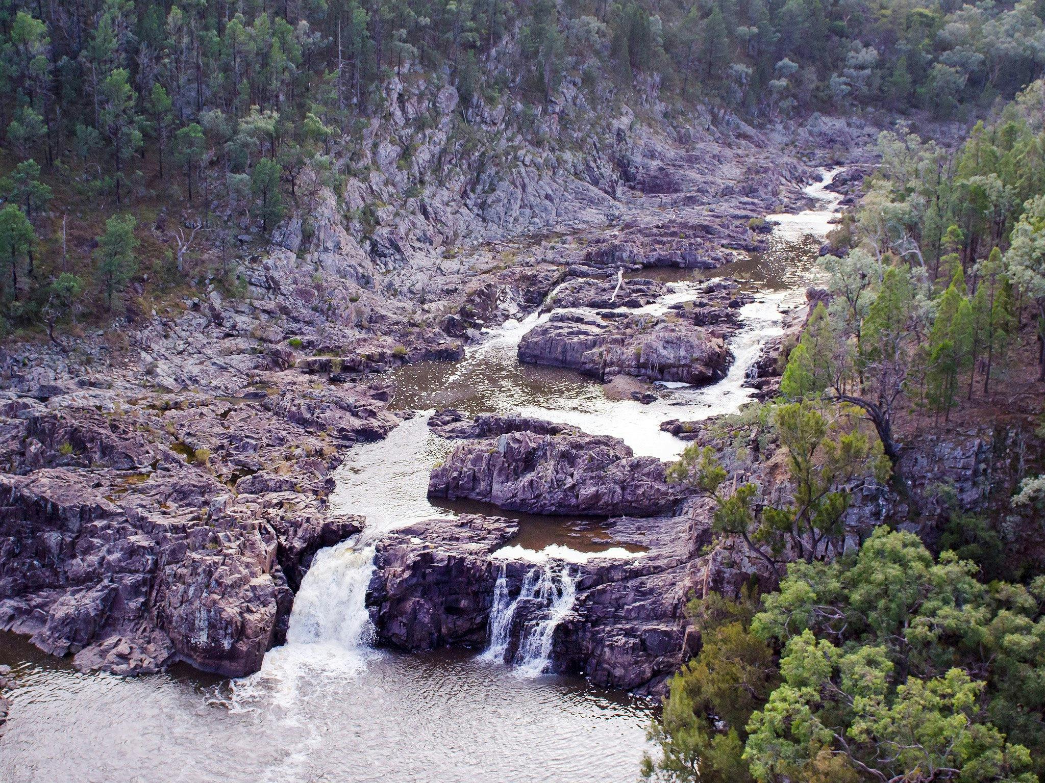 River and small falls in rocky ravine.