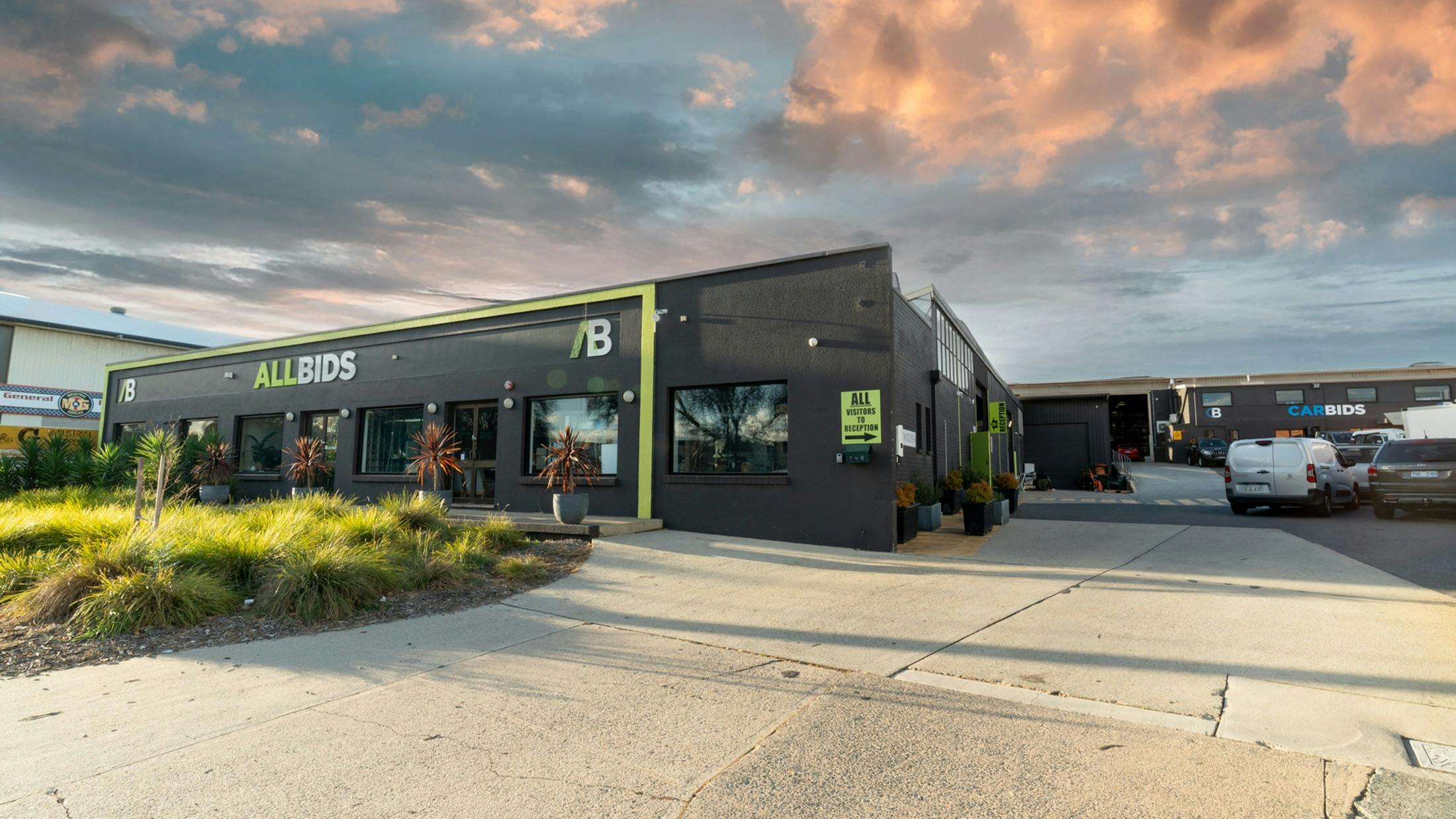Wide shot of outside of building showing the ALLBIDS and CARBIDS signage