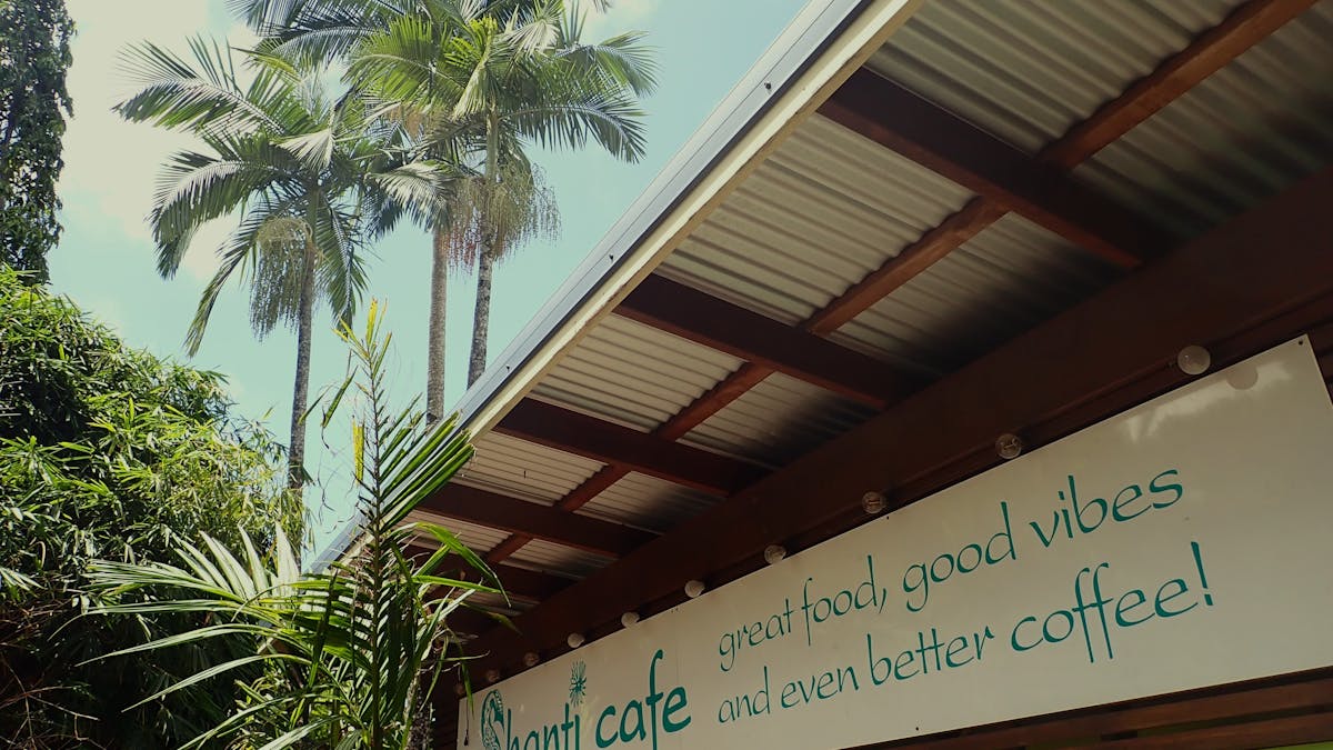 Front entrance with palm trees and blue sky, Shanti Cafe, Mission Beach, Queensland