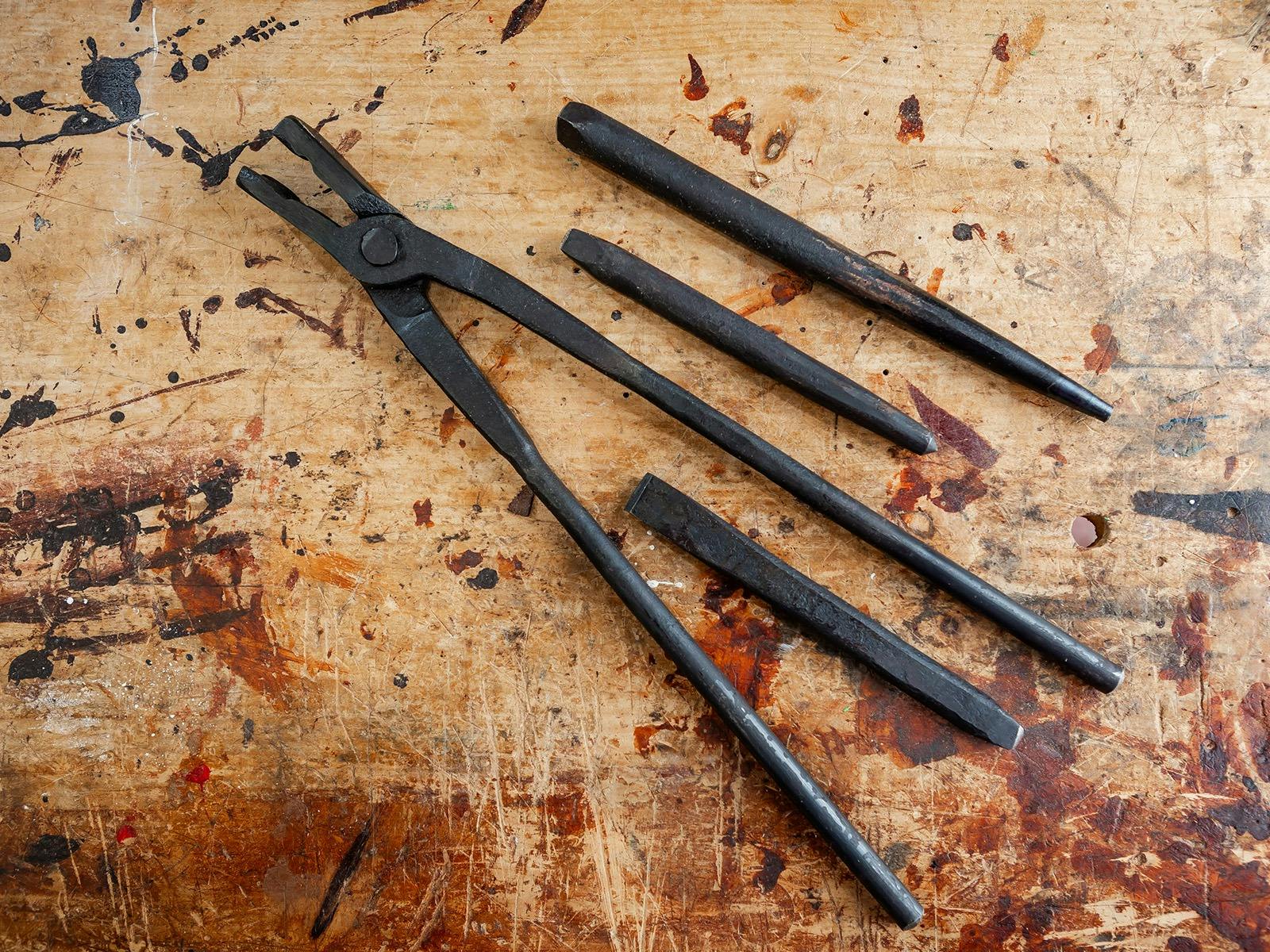 Blacksmithing tools resting on table.