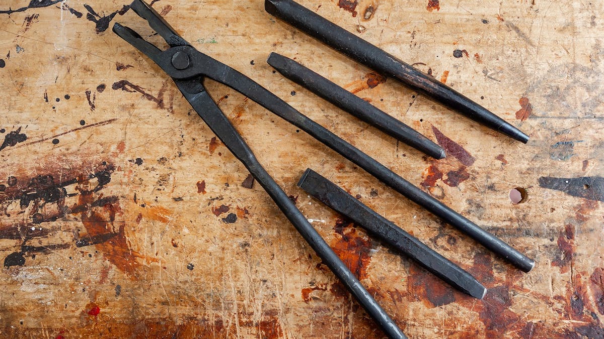 Blacksmithing tools resting on table.