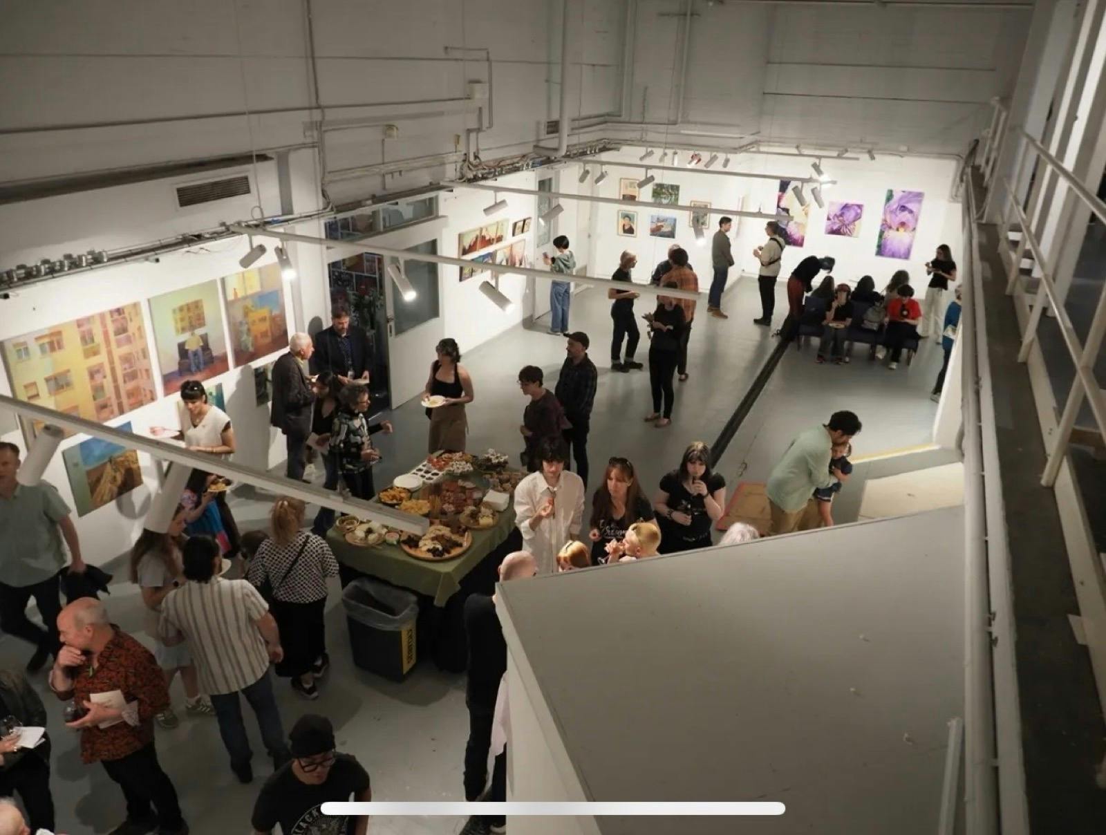 Image of multiple people gathering at the A Space Gallery for an exhibition of works